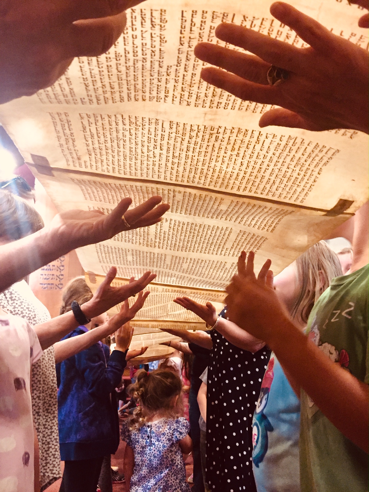 Torah unrolled hands lifting